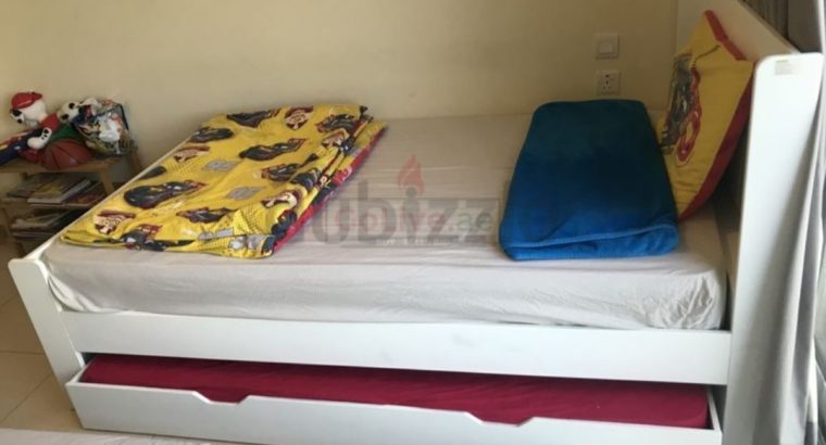 White bed with pullout bed.